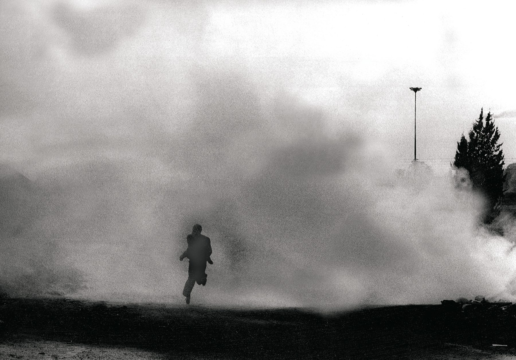 A Soweto resident runs from the toxic smell of teargas, 1976.